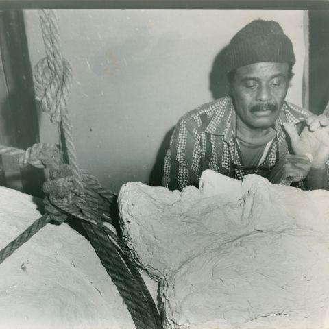 一个戴着帽子的黑人在弗雷德里克·道格拉斯的雕塑上工作的黑白照片