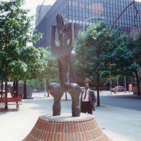 约翰·罗登在费城非裔美国人博物馆入口处的公共艺术雕塑前摆姿势的彩色照片.